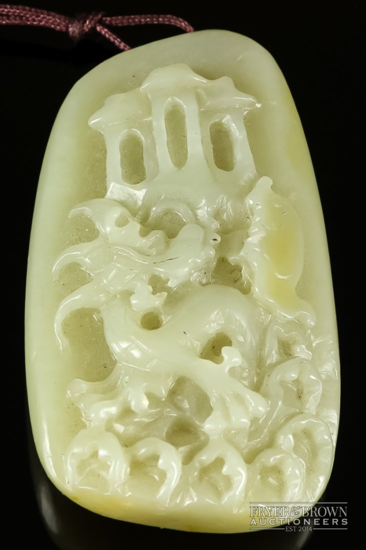 A Chinese mutton fat jade pendant, carved with a: A Chinese mutton fat jade pendant, carved with a stylised lion/dragon amidst waves, 6.5cm
