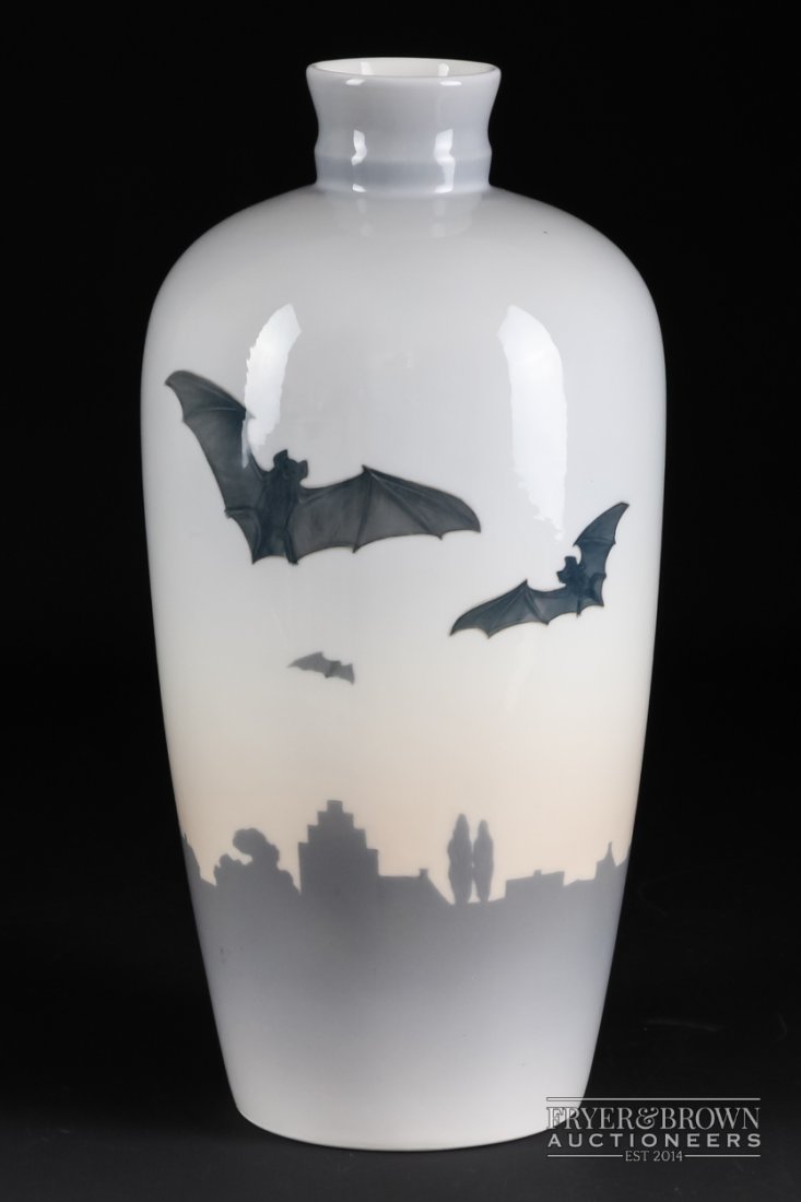 A Royal Copenhagen porcelain vase painted with a group: A Royal Copenhagen porcelain vase painted with a group of bats over a silhouette of a townscape, printed and painted marks, 26cm high