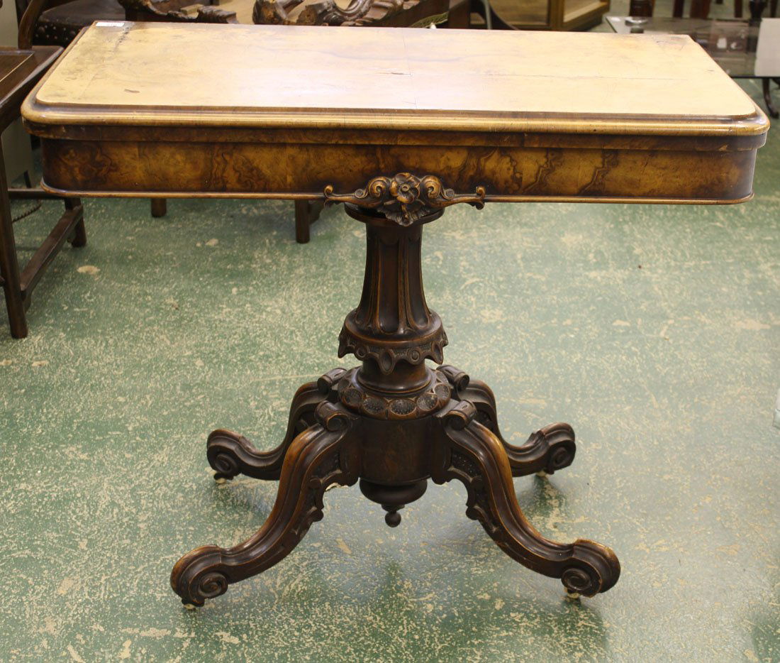 A Victorian burr walnut card table, rounded rectangular: A Victorian burr walnut card table, rounded rectangular top with foliate scroll decorated apron, on four 'c' scroll legs, ceramic castors, folded dimensions 92 x 46 x 77cm