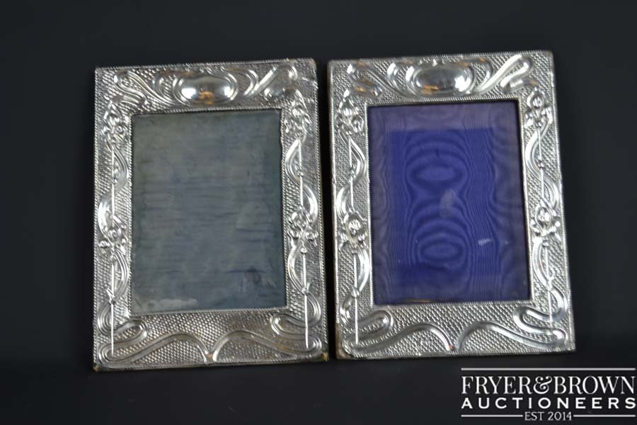Two Art Nouveau silver mounted photograph frames,: Two Art Nouveau silver mounted photograph frames, rectangular with a design of stylised lilies with scrolling foliage on an ozier ground, Chester 1906 and 1904, makers marks of JD over WD for James De