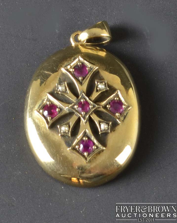 A late Victorian gold, ruby and split pearl locket,: A late Victorian gold, ruby and split pearl locket, c1890, the oval shaped locked applied star design panel, set with rubies and split pearls, glazed compartment to the reverse