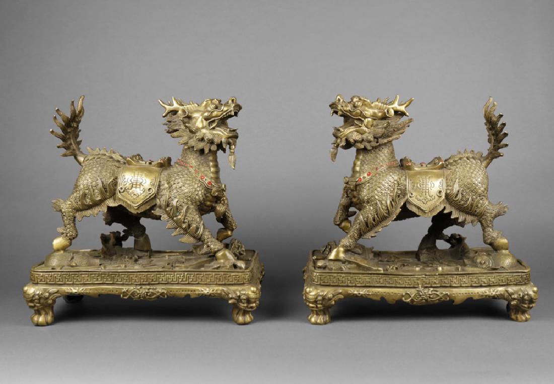 Pair of Chinese Brass Qilin figures, ca, 1950: Pair of Chinese Brass Qilin figures, ca, 1950 Each raised on a rectangular plinth, with applied red jewels 15 in. h. x 15 in. w.