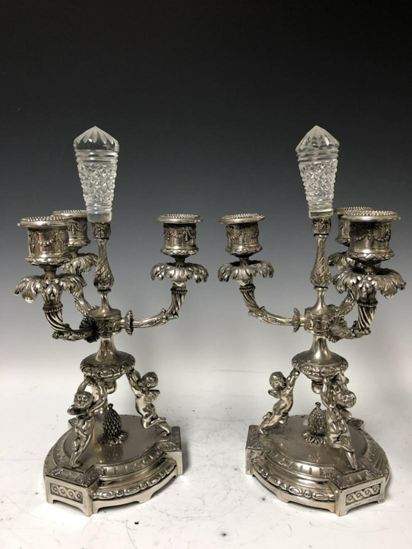 Pair of Pairpoint Silver Bronze Figural Candelabra: Pair of Pairpoint Silver Bronze Figural Candelabras, Depicting Puttis. Provenance from a Queens Home. Generally Good Condition. Dimensions- H-12.5" x W-7".