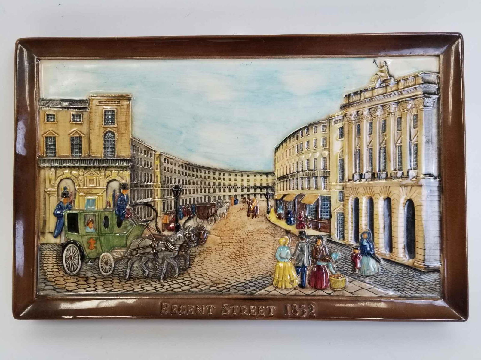 Regent Street 1852 Wall Majolica Plaque: Regent Street 1852 Wall Majolica Plaque Depicting Buildings, People, Horse & Carriage on Cobble Stone Street. Made by Beswick, England. Generally Good Condition. Provenance From a New York Home. Dimen