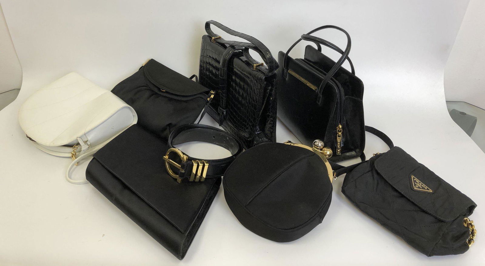 8pc Lot of Designer Items Including 7 Bags &1 Belt: 8pc Lot of Designer Items Including 7 Bags & 1 Belt. Included Salvatatore Ferragamo White Leather Bag, St. John Made in Italy Black Leather Bag, Prada Milano Made in Italy Black Shoulder Bag, Salvator