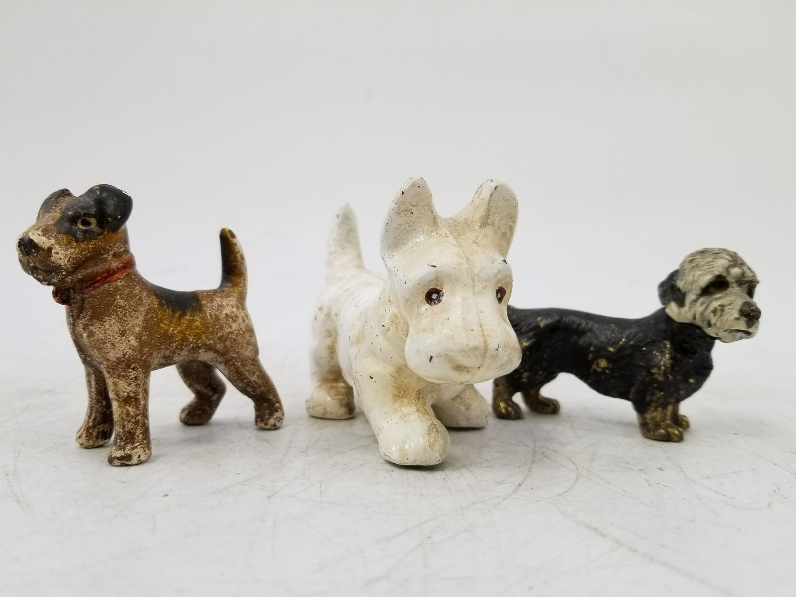 2 Cold painted Bronze Figures of Dogs and 1 other: 2 Cold painted Bronze Figures of Dogs and a Cast Metal Example. Generally good condition according to age. Dimensions: Largest L 4" Provenance: From a Long Island Estate. Please note the absence of a 