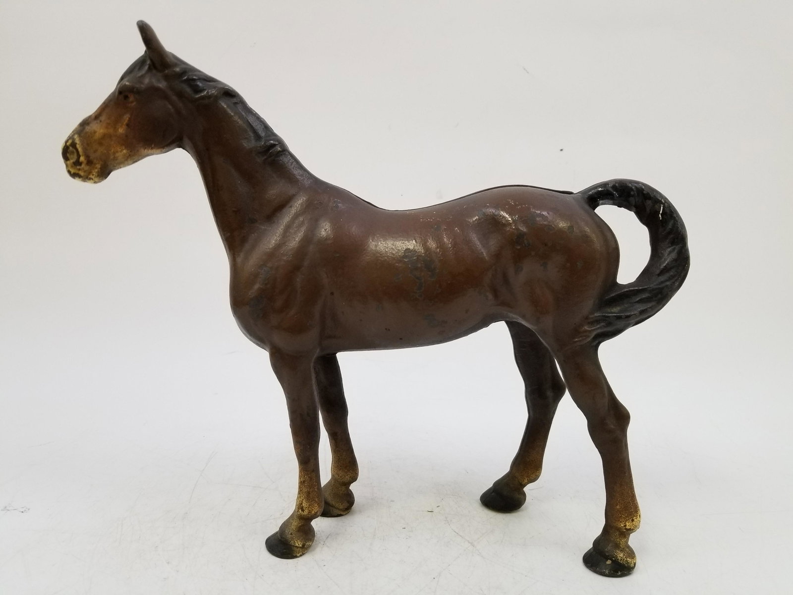 Vintage Painted Cast Iron Door Stop Shape of Horse 1930: Vintage Painted Cast Iron Door Stop in Shape of a Horse Circa 1930's. Generally good condition. Dimensions: L11.25, H 9.75" Provenance: From a Long Island Estate. Please note the absence of a conditio