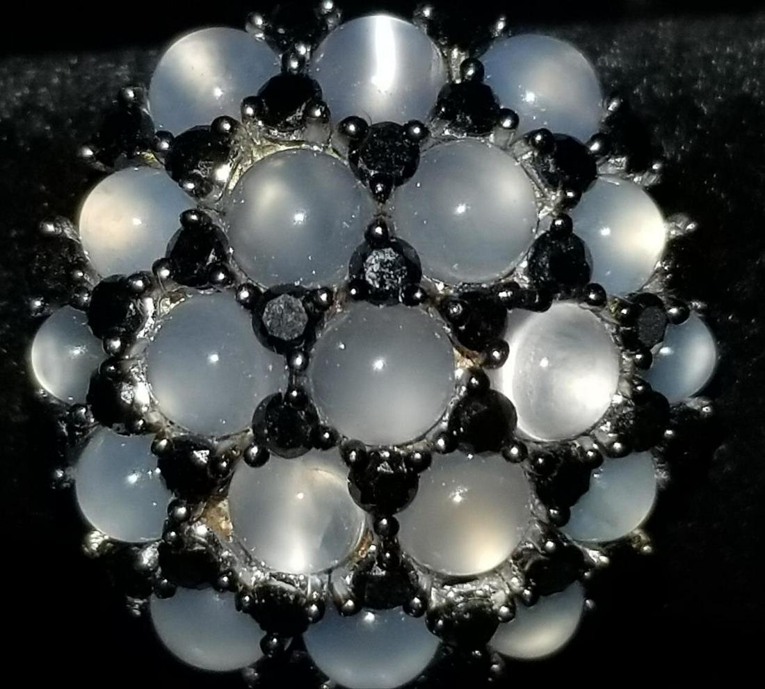 18K White Gold, Black Diamond & Moonstone Ring.: Unusual 18K White Gold, Black Diamond & Moonstone Ring. There are 1.18 Carats of Black Diamonds. And 4 Carats of Moonstones. Condition: Excellent.Dimensions: Ring Size- 6.5. Top- Dia-.75".Total Weight