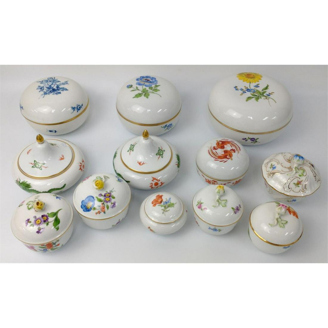12 Meissen Porcelain Covered Boxes in Various Size: 12 Meissen Porcelain Covered Boxes in Various Sizes. With Designs of Flowers, Butterflies and Green Dragons. 1 Very Large, 2 Large & 9 Others. Condition: 9 are in excellent condition. 2 finials have m
