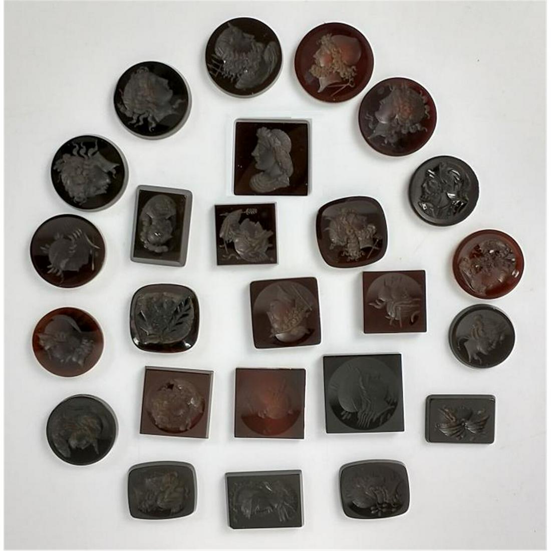 25 Antique Carved Intaglio Glass Pieces: 25 Antique Carved Intaglio Glass Pieces In Various Shapes & Sizes. Mostly Dark Amber Colors. Condition: Generally Good Condition. Dimensions: Largest- .75" Square. Provenance: From a Long Island, NY E