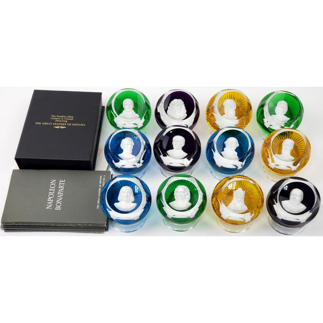 Set of 12 Baccarat Color Glass Paper Weights: Set of 12 Baccarat various Color Cameo Glass Paper Weights. "The Great Leaders of History". With Certificate of Authenticity and Plastic Stands.Condition: 11 are in excellent condition and 1 has a bru