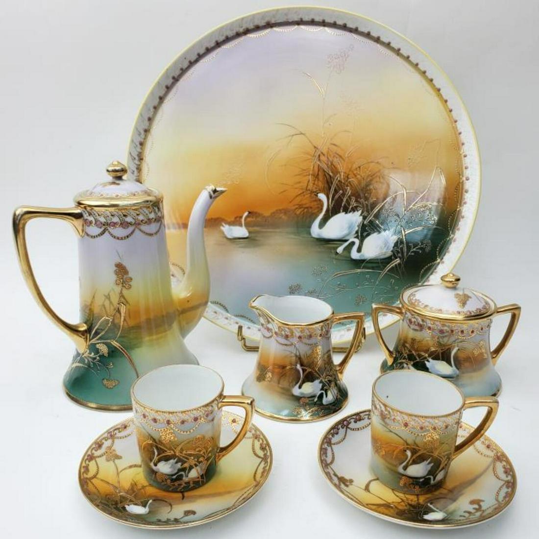 Nippon Art Deco Japanese Porcelain Tea Set: Fine Hand Painted Nippon Art Deco Japanese Porcelain Tete a Tete Tea Set with Decorations of Swans, Raised Gilt and Pink Jewels. Fully Signed. This lot includes coffee pot, covered sugar, milk, pair o