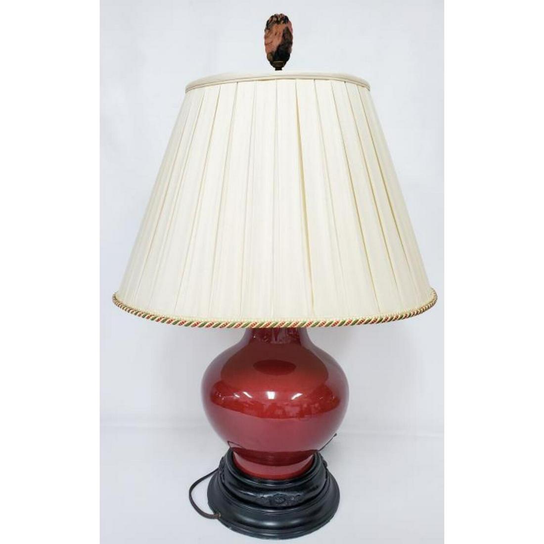 Chinese Ox Blood Lamp on Original Wood Base: Chinese Ox Blood Lamp on Original Wood Base.Condition: Generally Very Good.Dimensions: Total H- 26".Provenance: From a Queens, NY Home.Please note the absence of a condition report does not imply that
