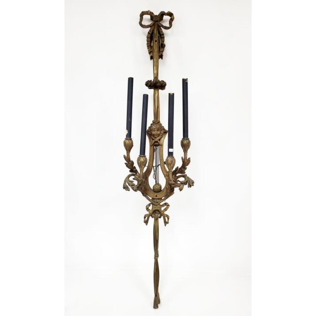 Monumental Antique Bronze 4 Arm Sconce: Monumental Antique Bronze 4 Arm Sconce with Bow Knot and Tassel Decorations and a Figural Face. Condition: Generally Very Good with Some Paint Residue in Some Areas. Dimensions: H- 53.25". Provenance: