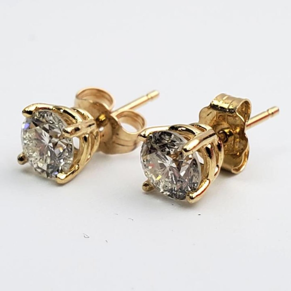 14K Gold and Diamonds Stud Earrings: 14K Gold and Diamonds Stud Earrings. There are 1ct of Diamonds. Condition: Excellent. Dimensions: Dia- 0.25". Total Weight: 0.7dwt / 1.1g. Provenance: From a Long Island, NY Home. Please note the abse