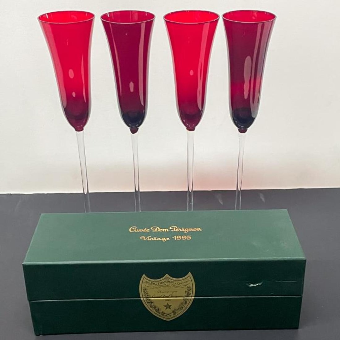 Vintage 1995 Dom Perignon Champagne & 4 Flutes: Vintage 1995 Dom Perignon Champagne in Sealed, Unopened Box Along with 4 Red Bohemia Champagne Flutes. Condition: Excellent, Sealed in Box. Some Scuffs to the Box. Dimensions: Box- 12.4" x 4.25" x 4".