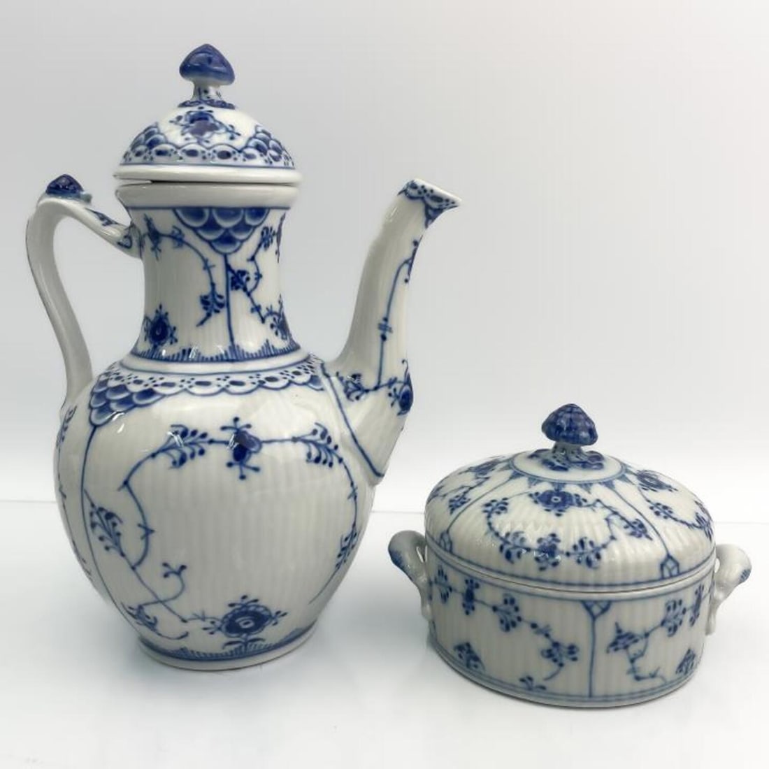 Royal Copenhagen Porcelain Blue Fluted Coffee/Bowl: Royal Copenhagen Porcelain "Blue Fluted" Half Lace Covered Coffee Pot with Acorn Knob Lid and Covered Bowl with Acorn Knob Lid. Condition: Excellent. Dimensions: Coffee Pot H- 8.75" x Handle to Spout-