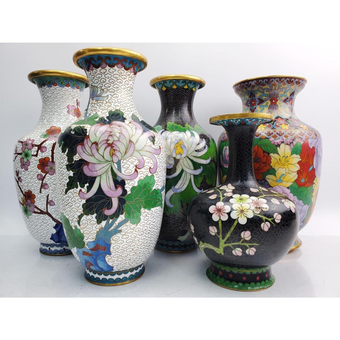 Lot of 5 Chinese Cloisonne Vases: Lot of 5 Chinese Cloisonne Vases. Condition: Generally Very Good. The Shorter Black One Has a Chip on One of the Flowers. Dimensions: Each of the White Vases H-9" x Dia-4.5". Provenance: From a Long I