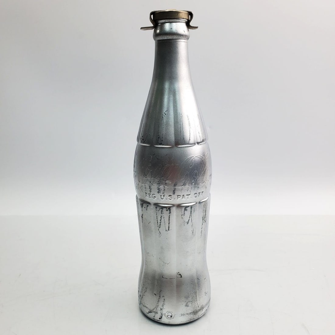 Attributed Andy Warhol Silvered Coca-Cola Bottle: After and Attributed Andy Warhol, American (1928-1987) Coca-Cola Silvered Glass Bottle. Affixed to the Bottom of the Bottle is a Paper Label Which Reads "You're In Andy Warhol". Affixed to the Cap of