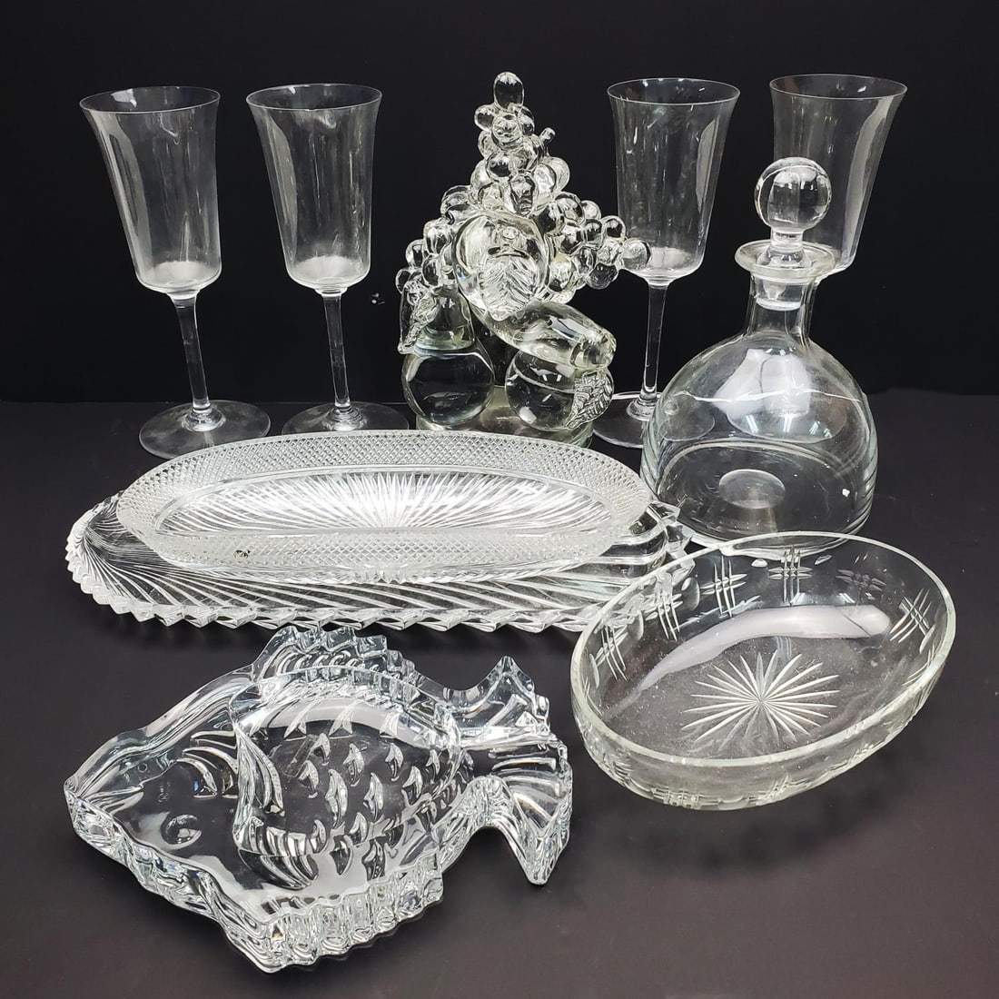 10 Piece Lot of Glass Items Incl. Glasses & Dishes: 10 Piece Lot of Glass Items Including a Fruit Shape Sculpture, a Decanter, 4 Wine Glasses, & Dishes. Condition: The Glasses Have Small Chips on The Rims. The Rest of The Items Are Generally Good. Dime
