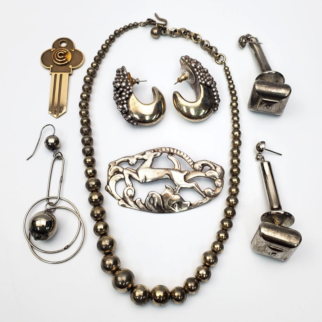 Lot of Sterling Silver Jewelry: Lot of Sterling Silver Jewelry Including 3 Pairs of Earrings, a Necklace & a Brooch. Along w/ a 12K Gold Filled Key. Condition: Generally Good. Dimensions: Various Sizes. Gross Weight of Silver: 76.5g
