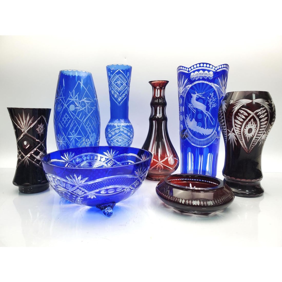 Lot of 8 Overlay Cut Glass Items: Lot of 8 Overlay Cut Glass Items Including 6 Vases, a Bowl, & an Ashtray. Condition: Generally Very Good. Dimensions: Largest (Vase)-H-10.8" x Dia-5". Provenance: From a Long Island, NY Home. Please n