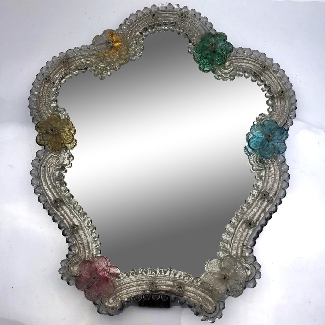 Vintage Murano Italy Easel Back Mirror: Vintage Murano Italy Easel Back Mirror w/ Multi Color Flowers. Has The Original Sticker Label. Condition: Generally Very Good. Dimensions: H-15.5" x W-13.5". Provenance: From a New Jersey Home. Please