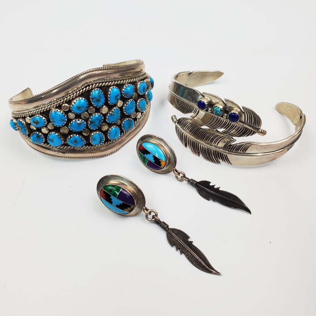 Lot of American Indian Sterling Silver Jewelry: Group Lot of American Indian Sterling Silver Jewelry Including 2 Cuff Bracelets & a Pair of Earrings. 1 Bracelet is Signed DALV. Condition: Generally Very Good. Dimensions: Larger Bracelet Dia-2.25".