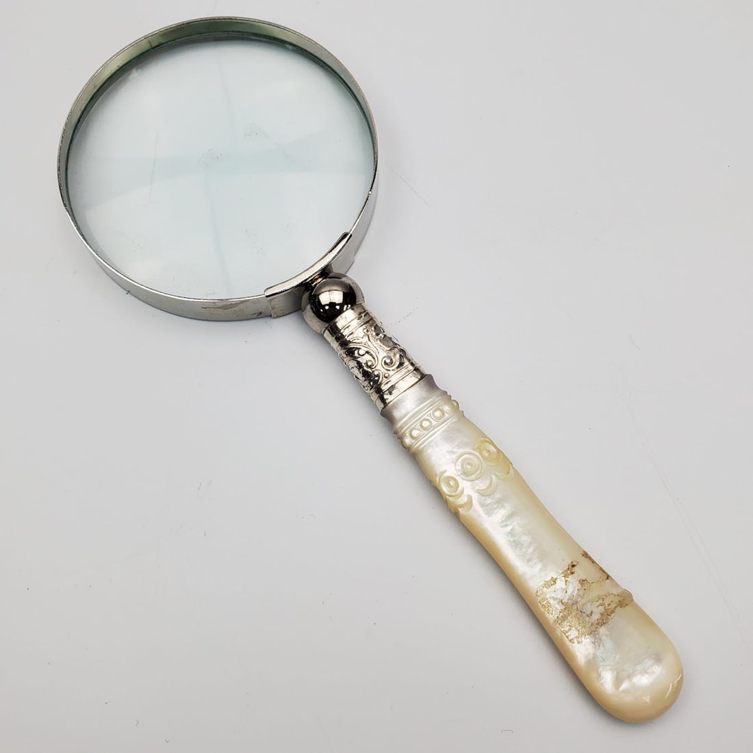 Mother of Pearl Handle Magnifying Glass: Mother of Pearl Handle Magnifying Glass. Condition: Generally Good. Dimensions: L-6" x W-2.5". Provenance: From a Long Island, NY Home. Please note the absence of a Condition Report does not imply tha