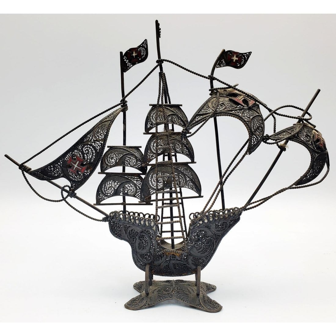 Silver Filigree w/ Enameled Portuguese Ship Model: Silver Filigree w/ Enameled Crosses Model of a Portuguese Galleon Ship. Condition: Generally Good, Highly Tarnished. Dimensions: L-9" x H-6.5". Weight: 108.6g/3.49ozt. Provenance: From a Long Island,