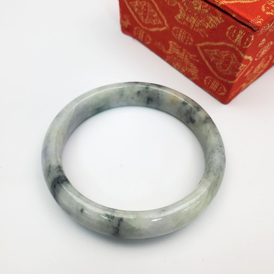 Chinese Jadeite Bracelet in Original Box: Chinese Jadeite Bracelet in Original Box. Condition: Generally Very Good. Dimensions: Bracelet Dia-3". Box L-3.75" x W-3" x H-1.75". Provenance: From a Long Island, NY Home. Please note the absence of