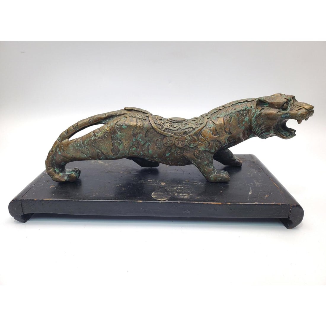 Chinese Probably Bronze Statue of a Tiger: Chinese Probably Bronze Statue of a Tiger w/ a Wood Stand. Condition: Generally Good w/ Oxidation. Dimensions: Statue L-9.5" x H-3" x W-2". Provenance: From a Long Island, NY Home. Please note the abs