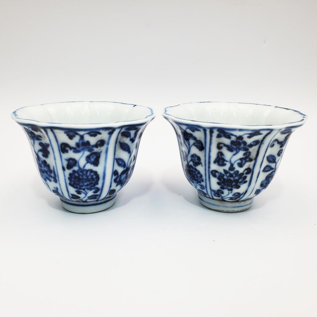 Chinese Porcelain Blue & White Tea Cups: Pair of Chinese Porcelain Blue & White Tea Cups w/ Decorations of Flowers. Condition: Generally Very Good. Dimensions: Dia-3.25" x H-2.5". Provenance: From a Long Island, NY Home. Please note the abse