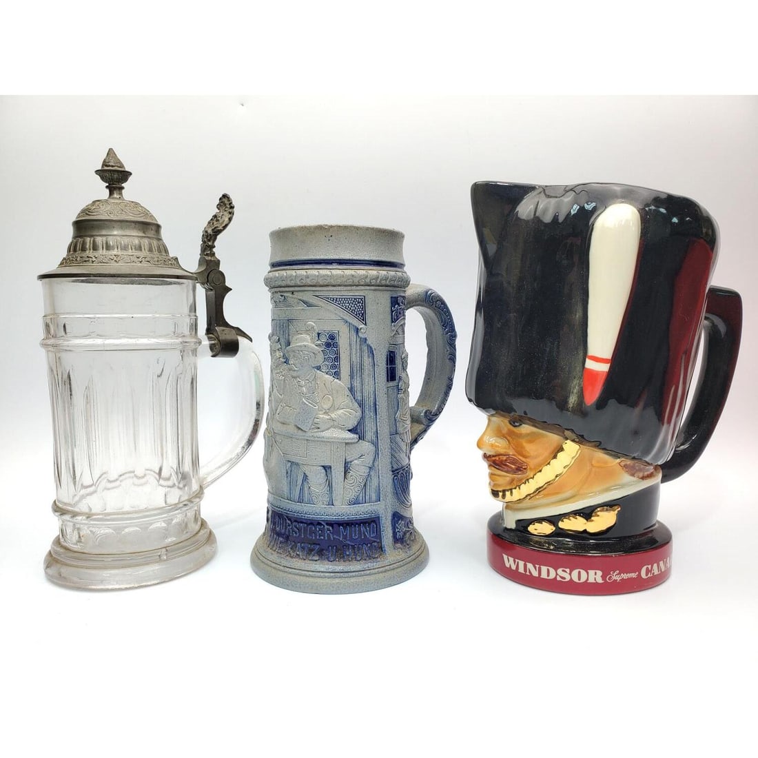 Lot of 2 Steins Along w/ a Another: Lot of 2 Steins Along w/ a Vintage Windsor Supreme Canadian Whiskey Cup. Condition: Sold As Is. Dimensions: H-8.5" x Dia-5". Provenance: From a Long Island, NY Home. Please note the absence of a Condi