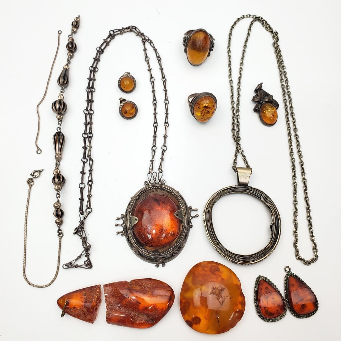 Lot of Amber Items: Lot of Amber Items Including Pendants, Rings, & Others. Some May Have Silver Mounts. Condition: As Found. Dimensions: Various Sizes. Provenance: From a Long Island, NY Home. Please note the absence of