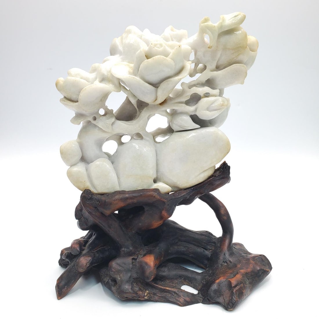 Chinese Carved White Jade on Original Wooden Base: Chinese Carved White Jade Depicting Flowers on Original Wooden Root Base. Condition: Generally Good. Dimensions: Total H-7.3" x W-5.8". Provenance: From a Long Island Home. Please note the absence of 