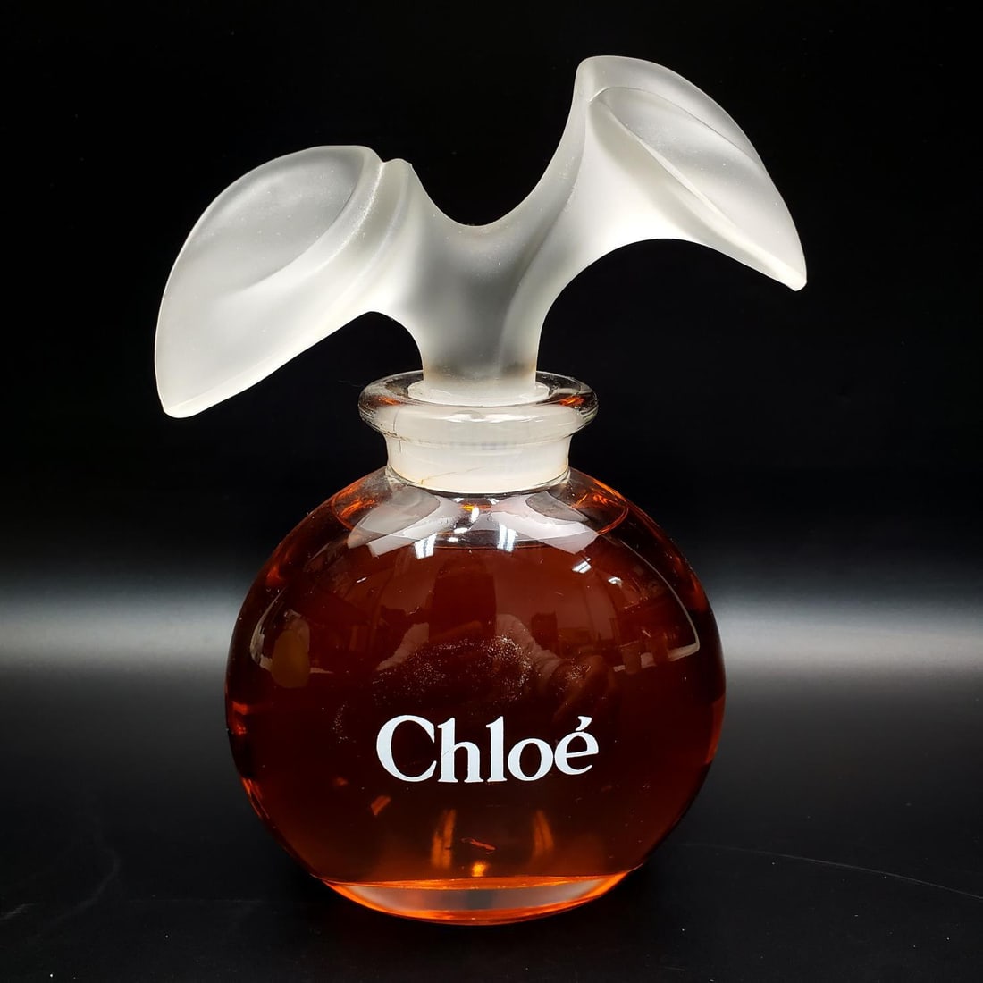Large Chloè Display Glass Perfume Factice Bottle: Large Chloè Display Glass Perfume Factice Bottle. Fully Marked. Condition: Generally Good. Dimensions: H- 8.5" x W- 5.75". Provenance: From a Long Island, NY Collector. Please note the absence of a C