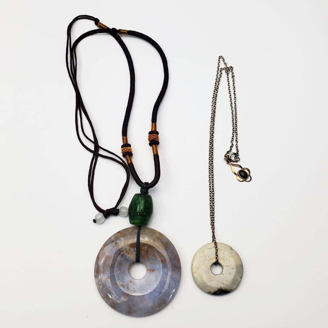 2 Chinese Vintage Donut Probably Jade Necklaces: Lot of 2 Chinese Vintage Donut Probably Jade Necklaces. Condition: Generally Very Good. Dimensions: Larger Jade Dia-2". Total L-28". Provenance: From a Long Island, NY Home. Please note the absence of