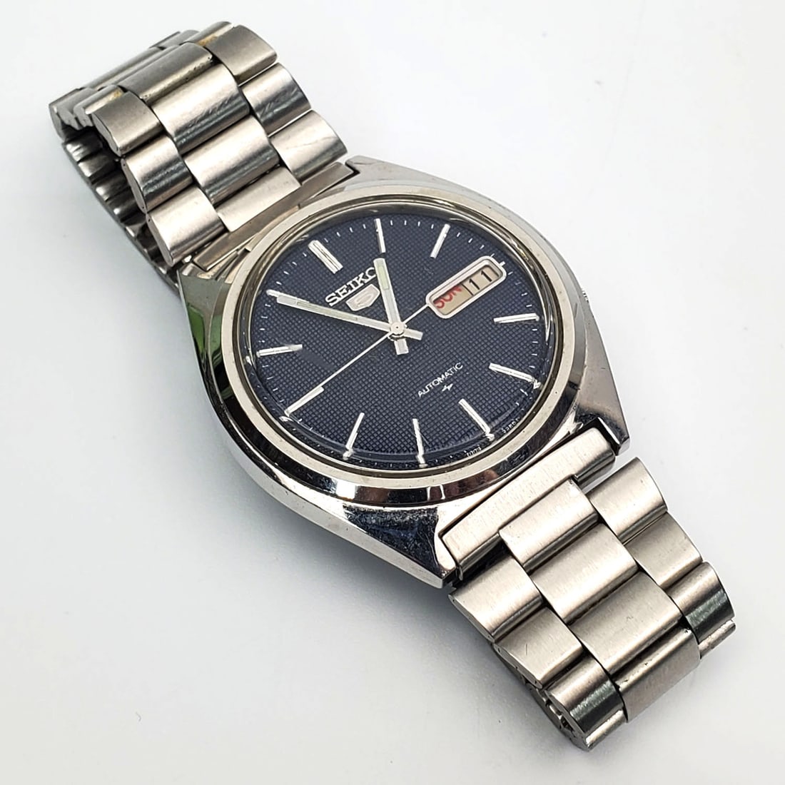 Vintage Seiko 5 Automatic Watch: Vintage Seiko 5 Automatic Watch. Condition: Generally Very Good. Please Note, We Do Not Guarantee The Workability or Mechanism of Any Watches or Clocks. Dimensions: Dia- 1.5". Provenance: From a Long