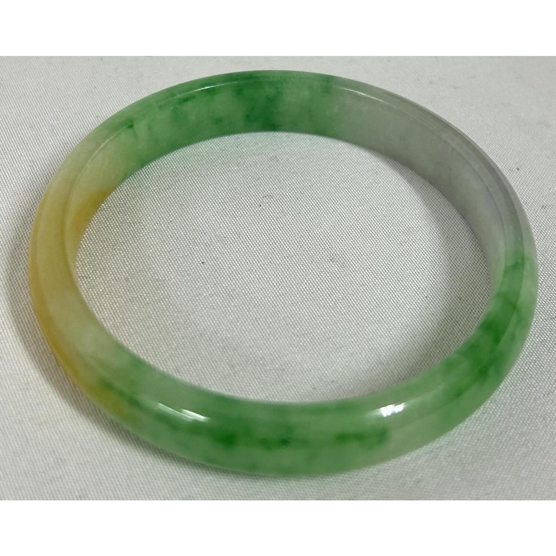 Chinese Jade or Jadeite Bangle Bracelet: Chinese Jade or Jadeite Bangle Bracelet. Condition: Generally Very Good. Dimensions: Outer Dia- 2.7" Inner Dia- 2.3". Provenance: From a Long Island, NY Home. Please note the absence of a Condition