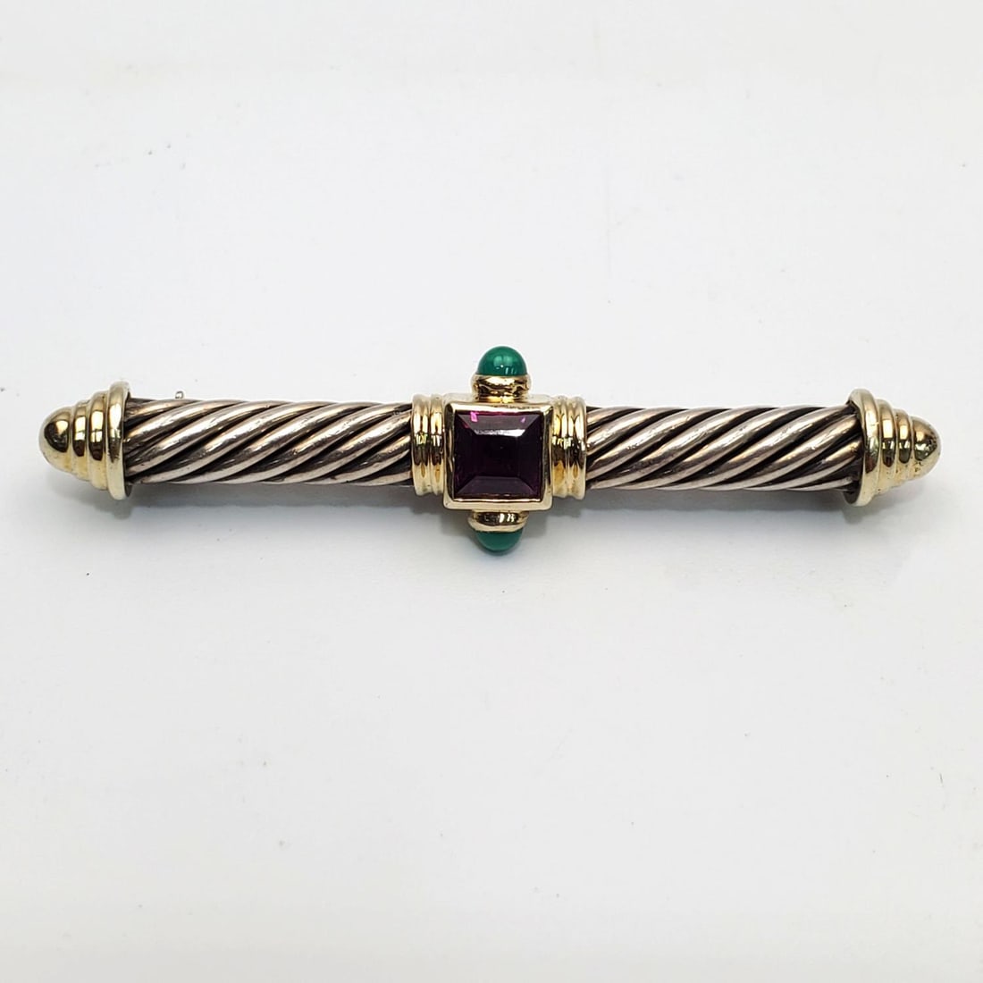 David Yurman Sterling Silver & 14K Gold Pin Brooch: David Yurman Sterling Silver & 14K Gold Pin w/ 2 Cabochon Emeralds & a Square Cut Amethyst. Fully Marked.Condition: Generally Very Good. Dimensions: L-2". Total Weight: 10.5g/0.34ozt. Provenance: From