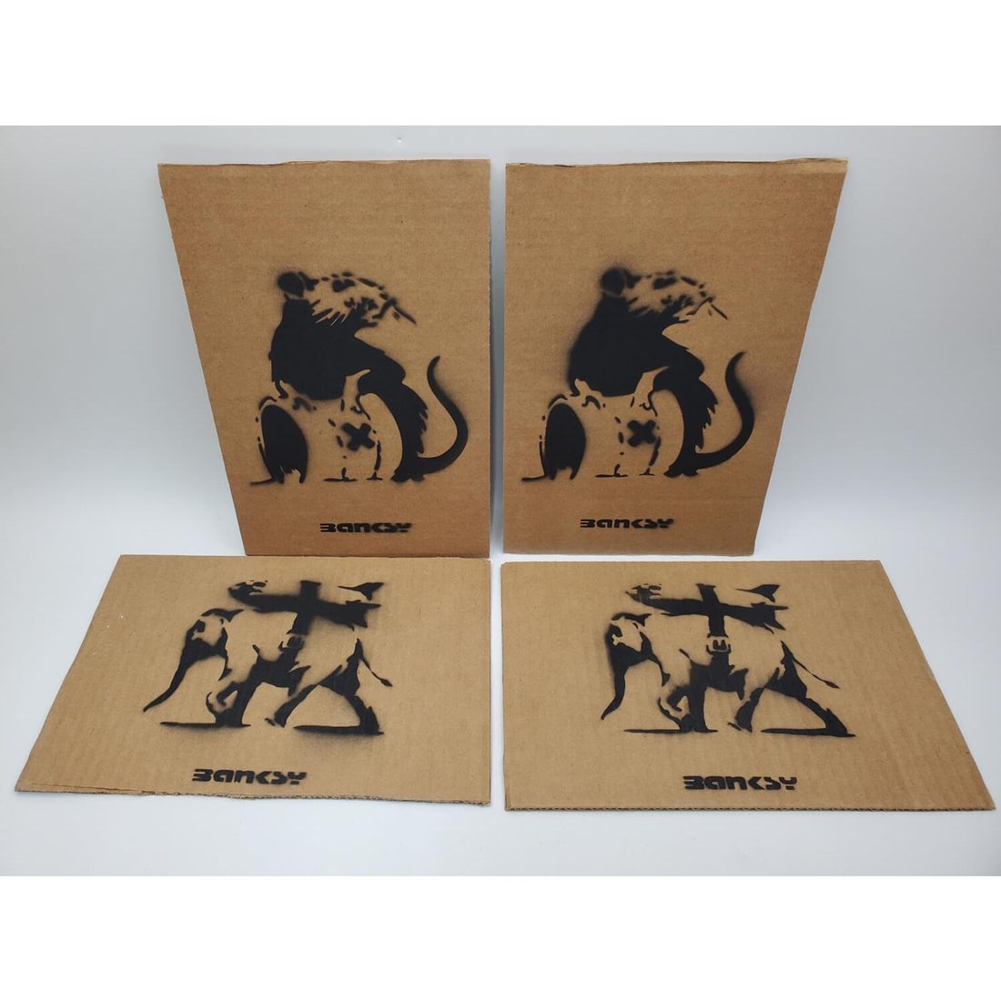 After Banksy, 4 Spray Paint Artworks: After Banksy, British, 4 Artworks, Spray Paint on Cardboard from "Dismaland" Exhibit. 3 Are Signed & Numbered w/ Dismaland Stamp on the Back. We Do Not Guarantee the Authenticity of This Item. Conditi