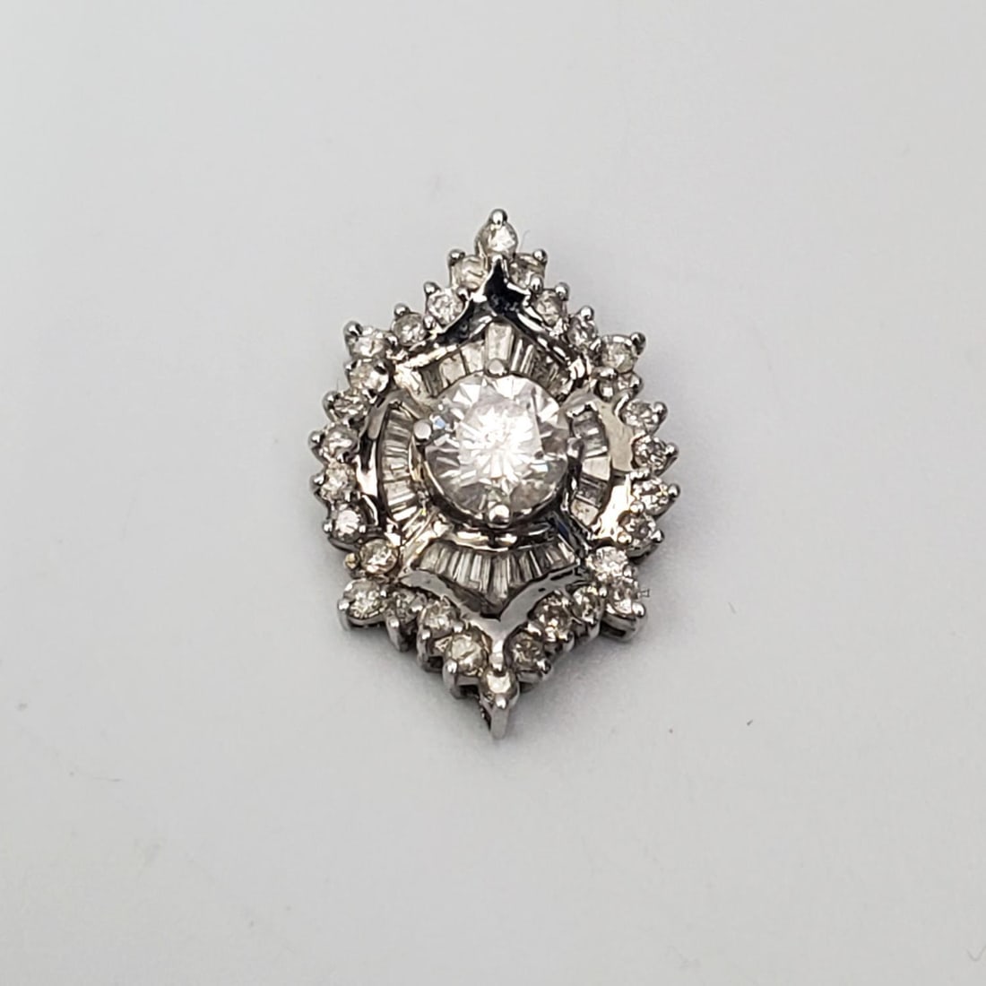 14 K White Gold & Diamonds Pendant: 14 K White Gold & Diamonds Pendant. The Center Diamond is Approximately Half Karat & Surrounded By Approximately 40 Small Round And Baguette Diamonds. Fully Marked. Please Note- Due to Recent Fraudule