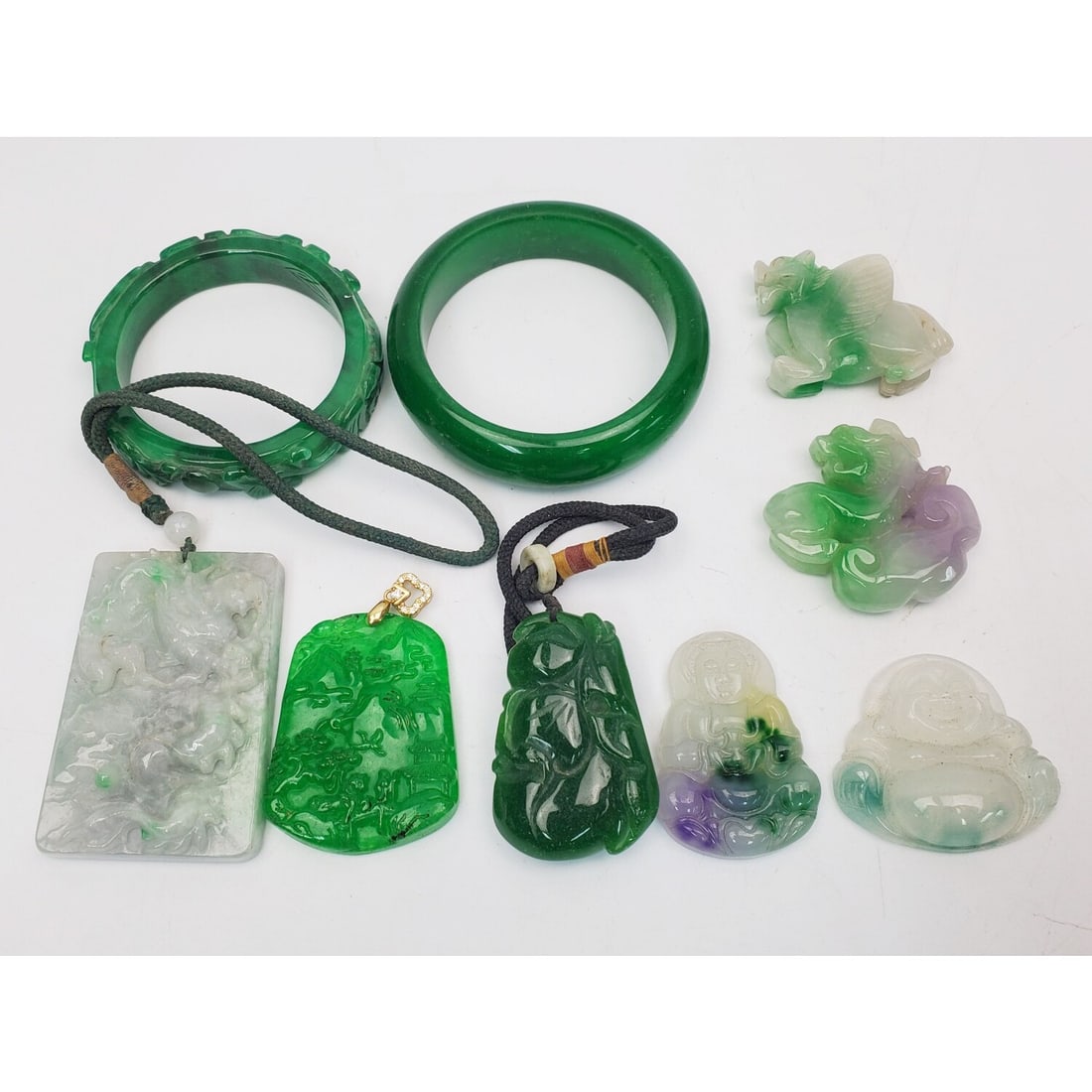 Lot of 9 Chinese Jade, Jadeite or Hard Stone Items: Lot of 9 Chinese Jade, Jadeite or Hard Stone Items Including Bangles, Pendants & Others. Condition: Generally Very Good. Dimensions: Largest Bangle-Inner Dia-2.5" Outer Dia-3.25". Provenance: From a L