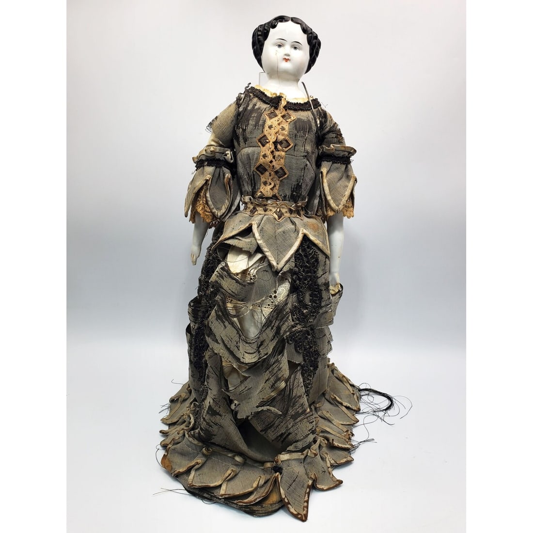 German Antique 19th C. Porcelain Head Doll: German Antique 19th C. Porcelain Head Doll on a Plexiglas Display Stand. Condition: With Damages. As Is. Dimensions: Total H-21.75" x W-8.75". Provenance: From a Long Island, NY Home. Please note the 