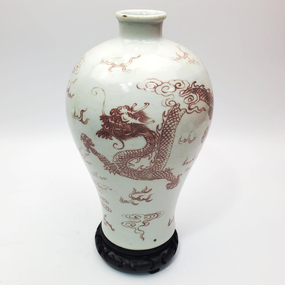 Chinese Porcelain Red & White Vase: Chinese Porcelain Red & White Vase Depicting Dragons. With Wood Base. Condition: Generally Good. Sold As Is. Dimensions: H- 10" x Dia- 6.25". Provenance: From a Long Island, NY Home. Please note the a