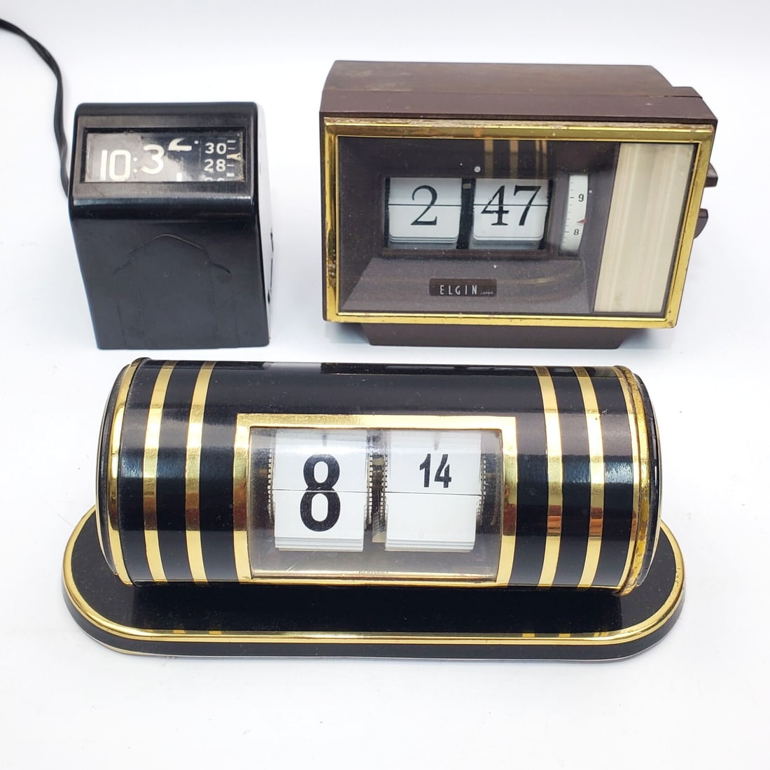 Lot of 3 Vintage Flip Clocks Inc. Elgin & Kohler: Lot of 3 Vintage Flip Clocks Including an Elgin Model 166506 Mechanical Flip Mantel Alarm Clock, a Kohler Cylinder Flip Clock & Another. Condition: Generally Good. Please Note- We Do Not Guarantee the
