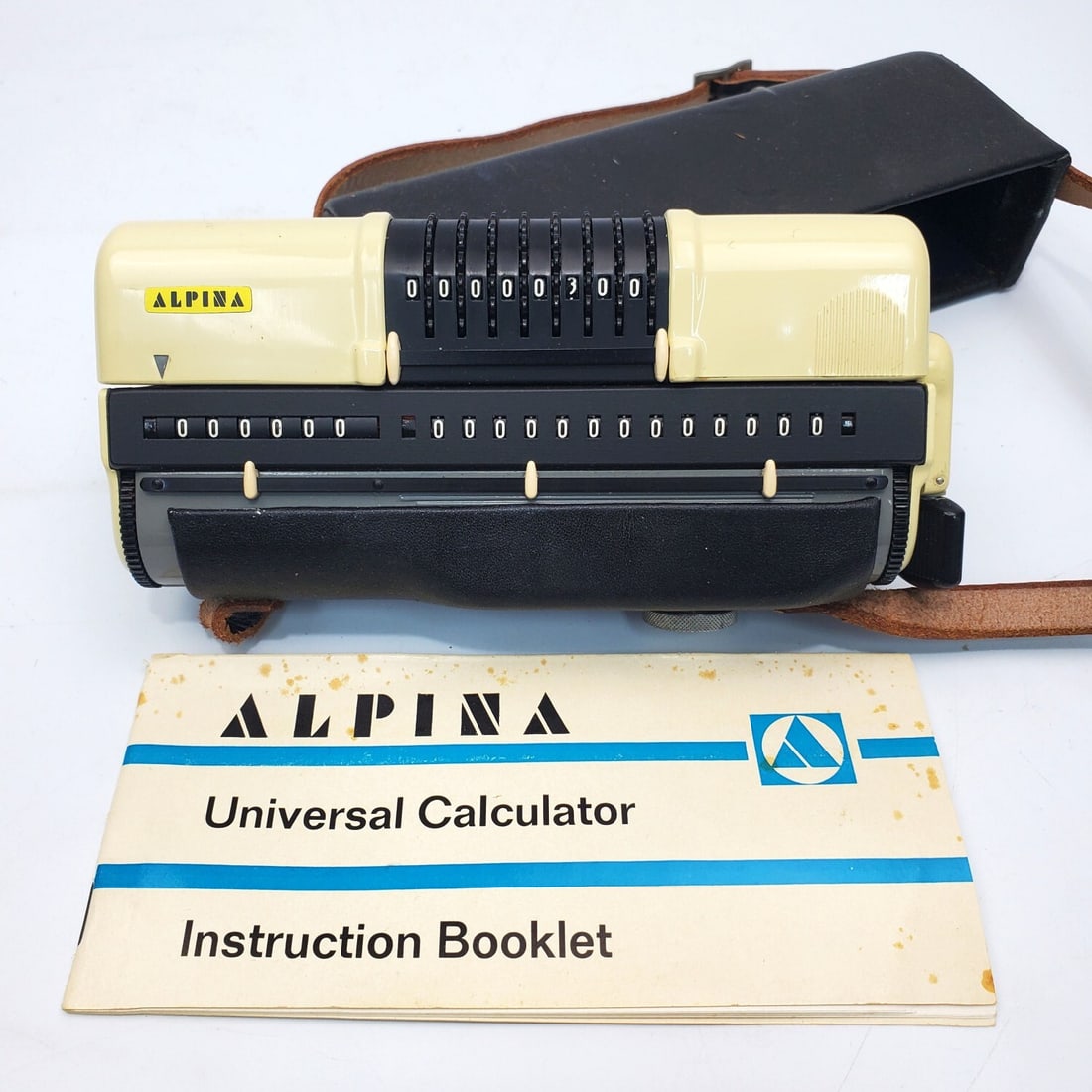Vintage Alpina Universal Mechanical Calculator: Vintage Alpina Universal Mechanical Calculator. Made in Germany c.1961. In Original Leather Carrying Case & w/ Instruction Booklet. Condition: As Found. Dimensions: Case (Excluding Strap)-L-7" x H-3.5