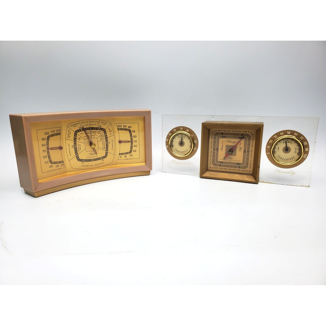 Lot of 2 Vintage Taylor Desktop Weather Stations: Lot of 2 Vintage Taylor Desktop Stormoguide Weather Stations. 1 is Brass & Acrylic Designed by Walter Dorwin Teaque in 1949 & The Other is Bakelite c. 1920's or 30's. Condition: As Found. Dimensions: 