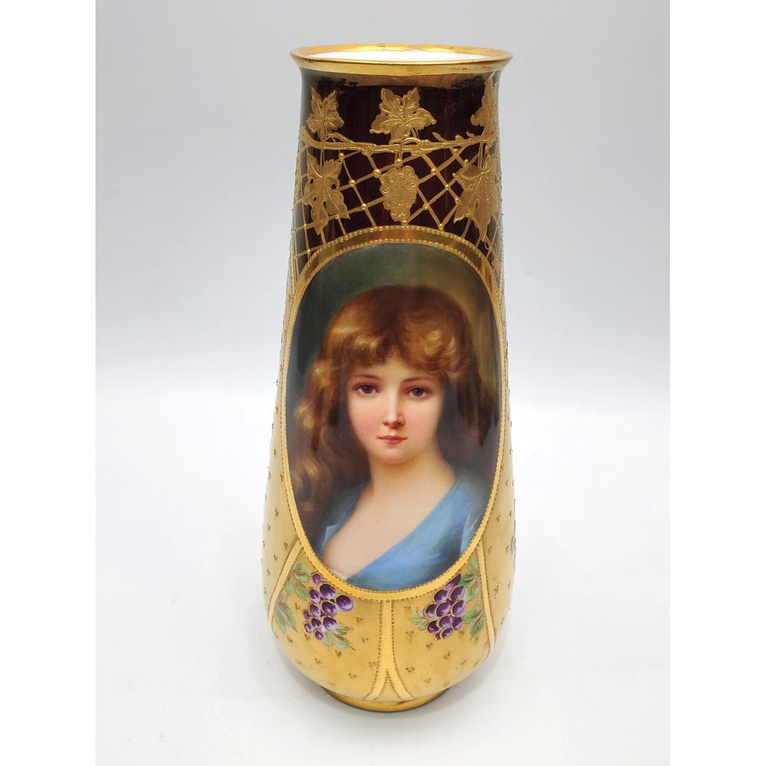 Antique Royal Vienna Style Porcelain Vase: Antique Royal Vienna Style Porcelain Vase w/ Hand Painted Decorations of a Young Girl "Cloto", Grapes & Heavy Gilt. Fully Marked. Condition: Generally Very Good. Dimensions: H-9.8". Provenance: From a